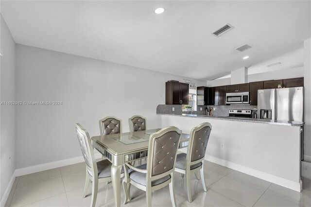 tiled dining room with lofted ceiling