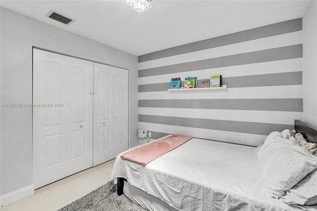 bedroom featuring light tile patterned floors and a closet