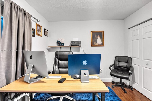 office area with a textured ceiling and dark hardwood / wood-style flooring