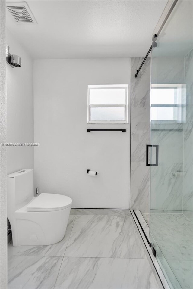 bathroom with toilet and an enclosed shower