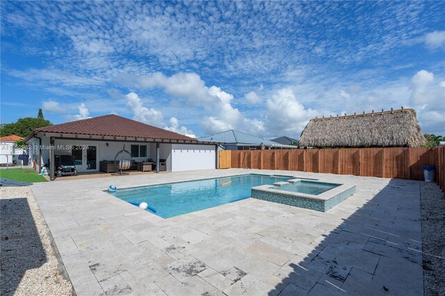 view of swimming pool featuring a patio and an in ground hot tub