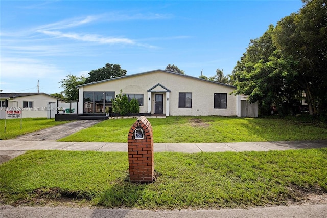 view of front of property with a front yard and a carport