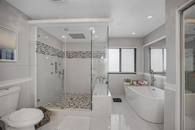 bathroom with separate shower and tub, toilet, and tile patterned floors