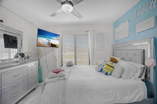 bedroom featuring ceiling fan, light tile patterned floors, and multiple windows