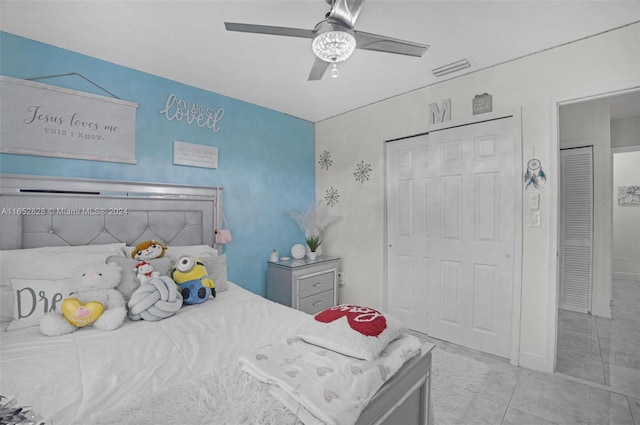 tiled bedroom with ceiling fan and a closet