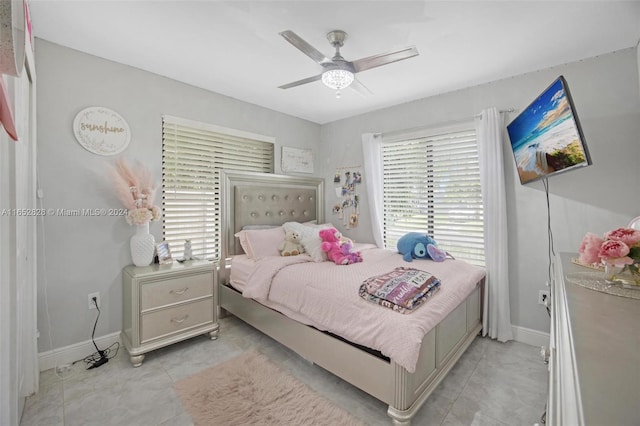 tiled bedroom featuring ceiling fan and multiple windows