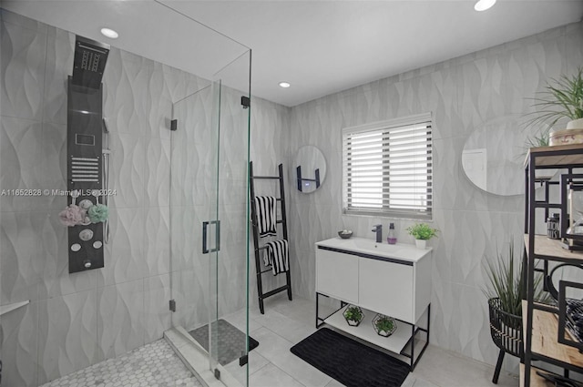 bathroom featuring vanity, tile walls, a shower with shower door, and tile patterned floors