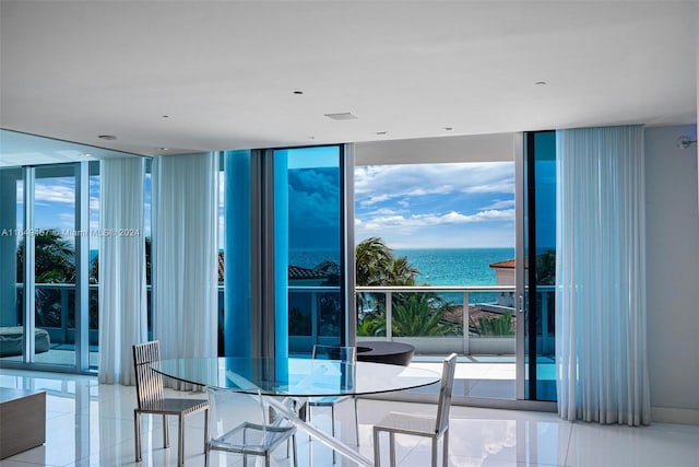 dining room with plenty of natural light, floor to ceiling windows, a water view, and light tile patterned flooring