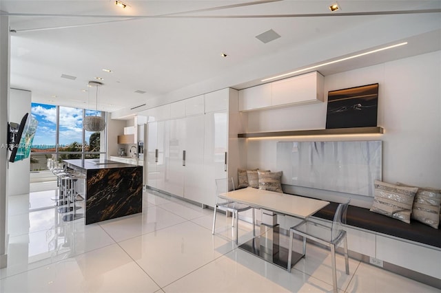 interior space with a kitchen island, light tile patterned floors, and floor to ceiling windows