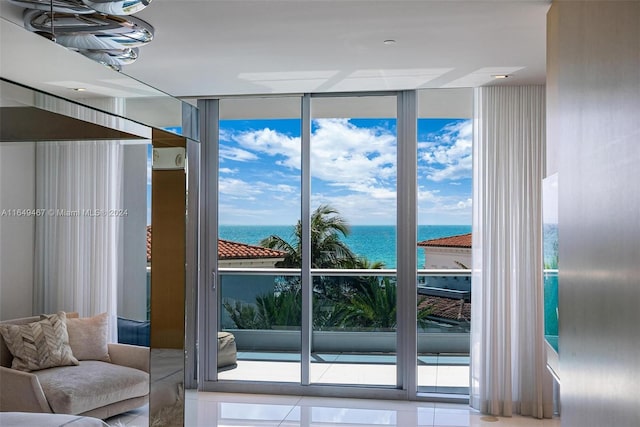 doorway to outside with a wall of windows, a water view, light tile patterned flooring, and a wealth of natural light