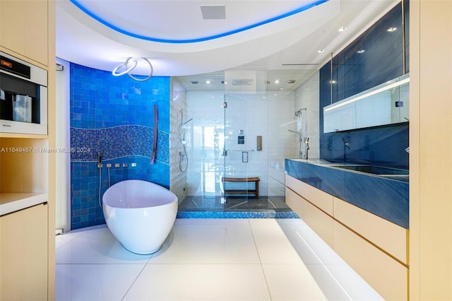 bathroom with tile patterned flooring, vanity, separate shower and tub, and tile walls