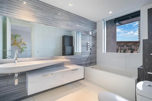 full bathroom featuring toilet, tile patterned floors, sink, shower / washtub combination, and tile walls