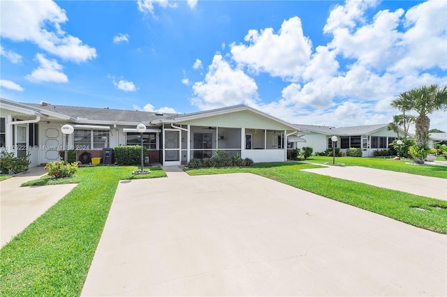 ranch-style home featuring a sunroom and a front lawn