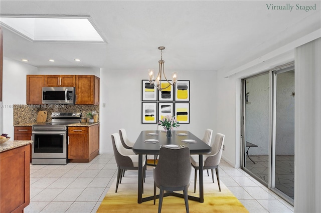 kitchen featuring hanging light fixtures, decorative backsplash, light stone countertops, stainless steel appliances, and a chandelier