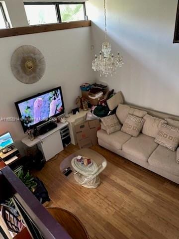 unfurnished living room featuring wood-type flooring and a notable chandelier