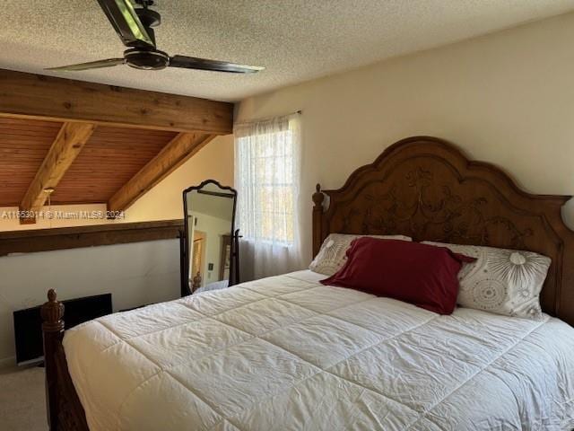 carpeted bedroom with a textured ceiling, wood ceiling, ceiling fan, and beam ceiling