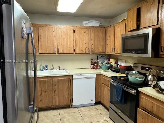 kitchen featuring appliances with stainless steel finishes, sink, and light tile patterned floors