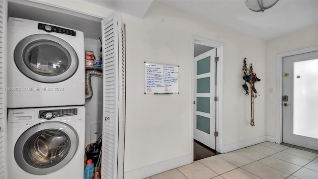 washroom featuring light tile patterned floors and stacked washer and dryer