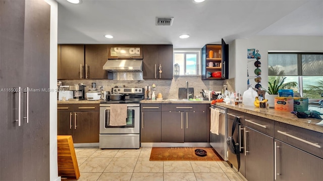 kitchen featuring dark brown cabinets, backsplash, appliances with stainless steel finishes, sink, and ventilation hood