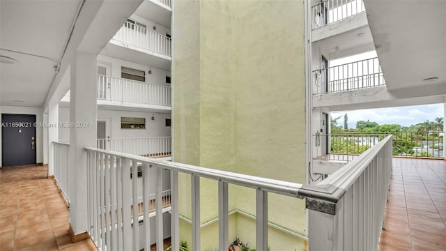 hall featuring a high ceiling and light tile patterned floors