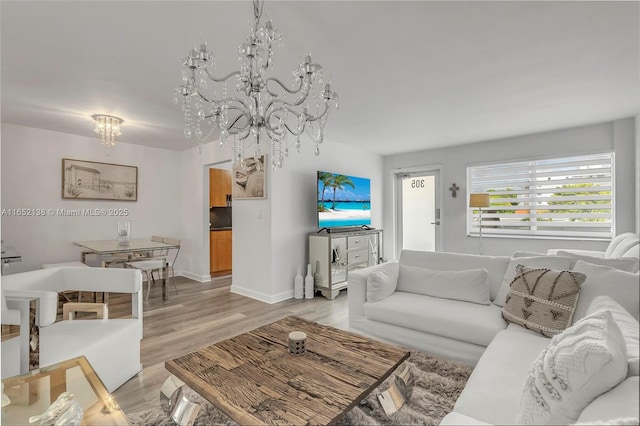 living room featuring an inviting chandelier and light hardwood / wood-style floors