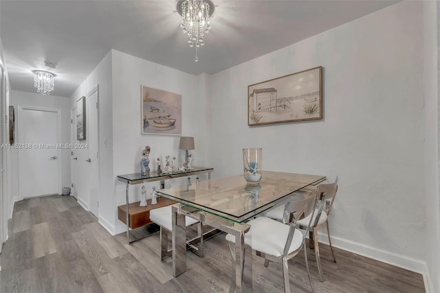 dining space with light wood-type flooring and a chandelier