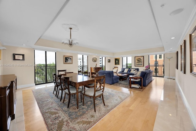 dining room featuring a chandelier, light hardwood / wood-style floors, and ornamental molding