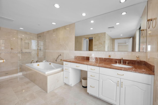 bathroom featuring vanity, independent shower and bath, tile walls, and tasteful backsplash