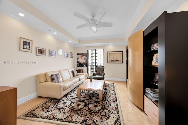 living room featuring crown molding, light hardwood / wood-style flooring, and ceiling fan