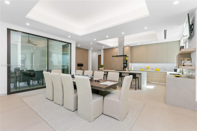 dining space featuring a raised ceiling and ceiling fan