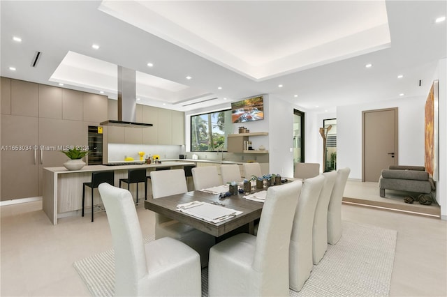 dining space with a tray ceiling and sink