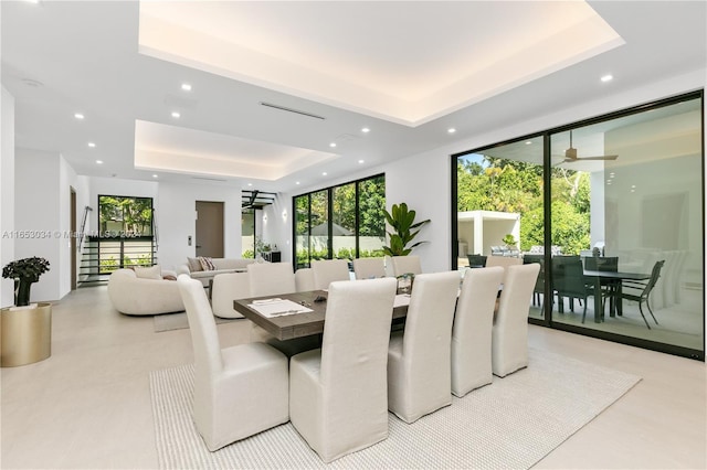 dining area with a wealth of natural light and a raised ceiling