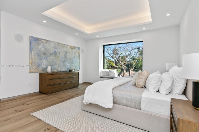 bedroom featuring a raised ceiling and hardwood / wood-style floors