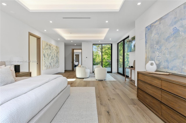 bedroom featuring light wood-type flooring and a tray ceiling