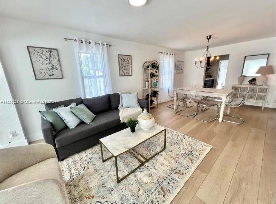 living room featuring a chandelier, hardwood / wood-style floors, and a healthy amount of sunlight