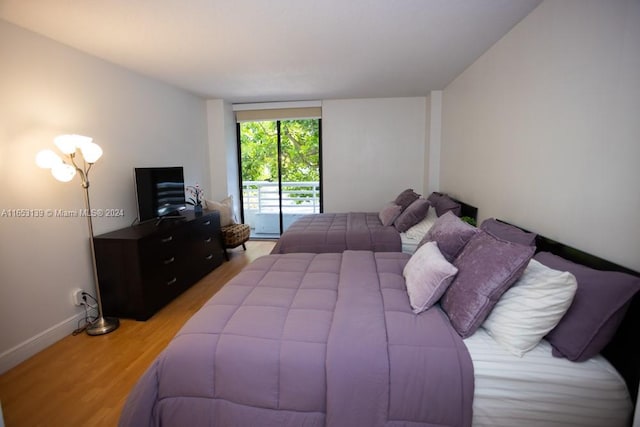 bedroom with access to exterior and light hardwood / wood-style flooring