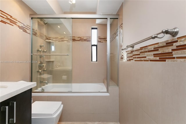 full bathroom featuring combined bath / shower with glass door, vanity, and toilet