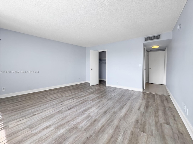 empty room featuring a textured ceiling and light wood-type flooring