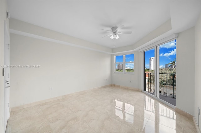 unfurnished room featuring a ceiling fan and baseboards