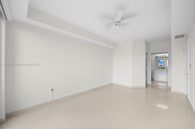 tiled empty room featuring ceiling fan