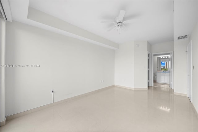 spare room with baseboards, tile patterned flooring, visible vents, and a ceiling fan