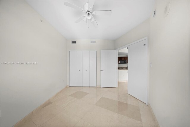 unfurnished bedroom with a closet, ceiling fan, and light tile patterned flooring