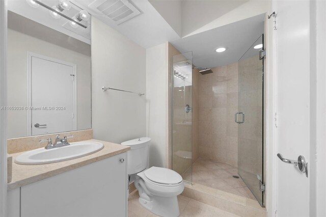 bathroom featuring a shower with shower door, tile patterned flooring, toilet, and vanity