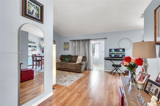 living room with a textured ceiling and light hardwood / wood-style flooring