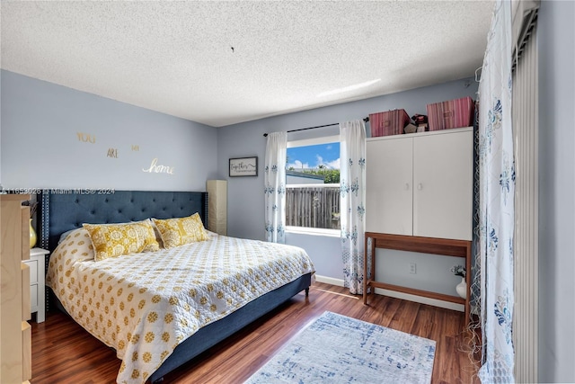 bedroom featuring dark wood-type flooring and a textured ceiling