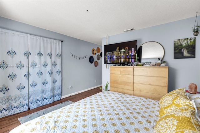 bedroom with wood-type flooring and a textured ceiling