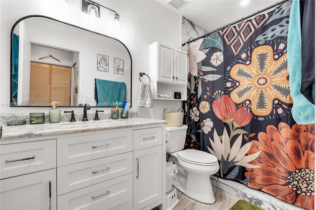 bathroom with walk in shower, toilet, and vanity