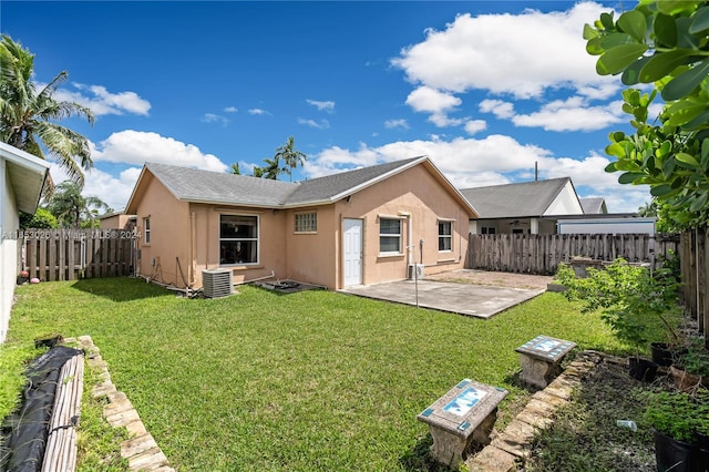 rear view of house featuring a lawn, a patio, and central AC