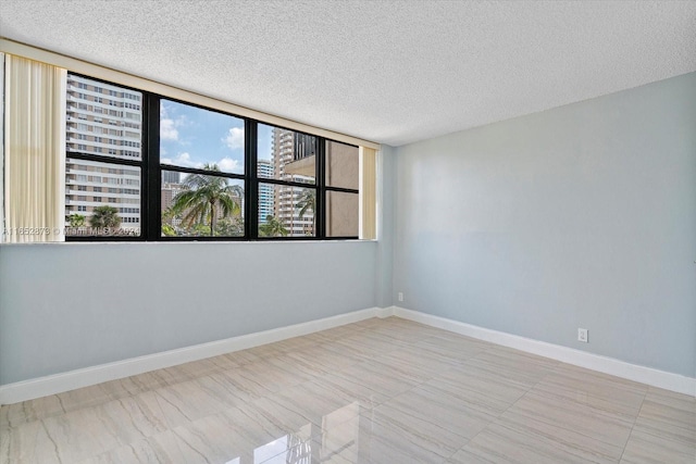 unfurnished room featuring a textured ceiling