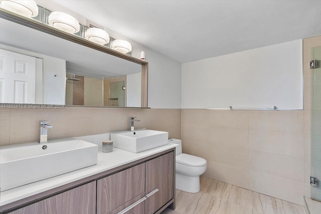 bathroom with toilet, a shower with door, vanity, tasteful backsplash, and tile walls